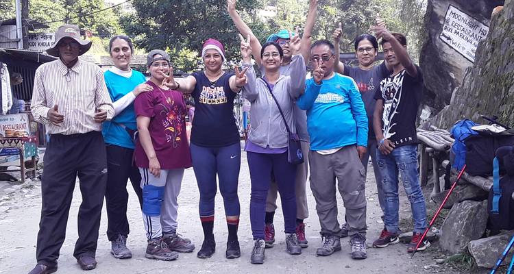 Gruppe von Wanderern, die fröhlich auf einem Dorfweg posieren.