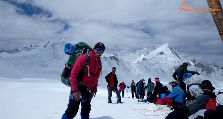 Group of climbers on a snowy mountain with promotional banners.