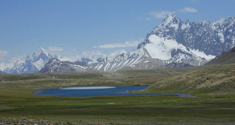 Scenic view of snow-capped mountains with a small lake.