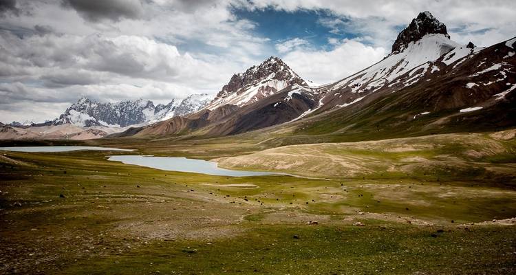Scenic mountain landscape with snow-capped peaks and a river.