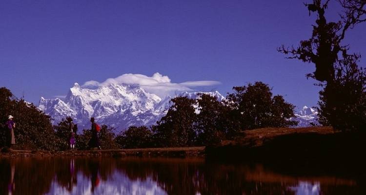 Mountain peak reflected in a tranquil water body with purple color tone.