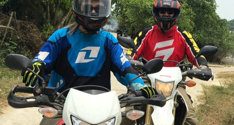 Two people in colorful motorcycle gear on bikes.