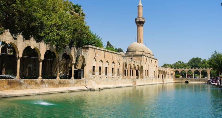 Historisches Bauwerk mit einem Torbogen neben einem Wasserbecken.