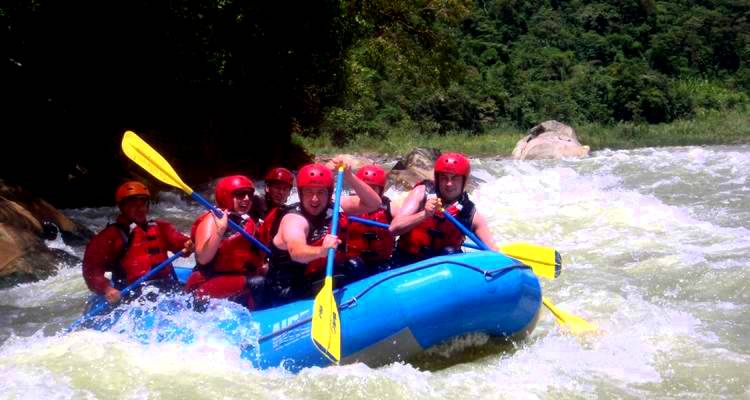 Group of people white-water rafting on a river.