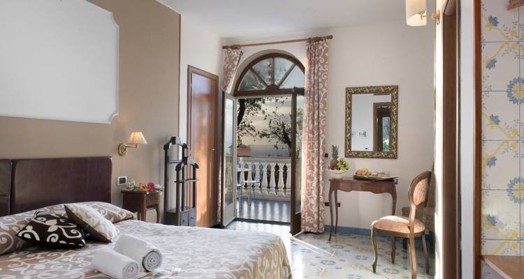 Chambre d'hôtel confortable avec vue sur un balcon et la mer.