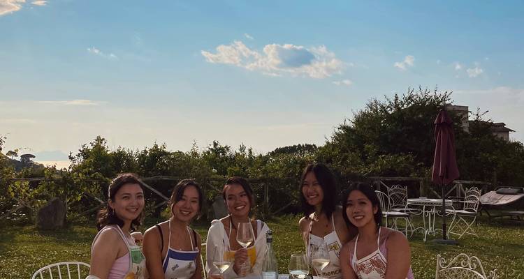 Un groupe de femmes assises dehors à une table avec des boissons.