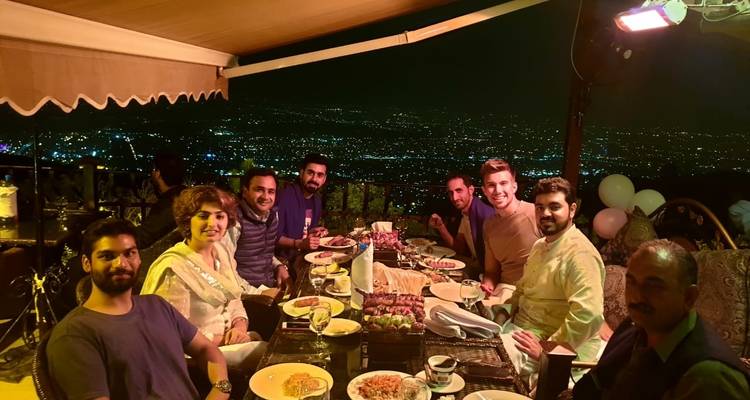 Reizigers die buiten dineren met uitzicht op de stadsverlichting.