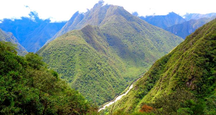 Uitgestrekte bergketens met een kronkelende rivier die door het weelderige landschap snijdt.
