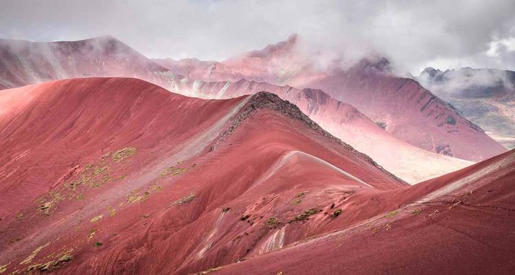 Nahaufnahme der rötlich getönten Grate des Rainbow Mountain.