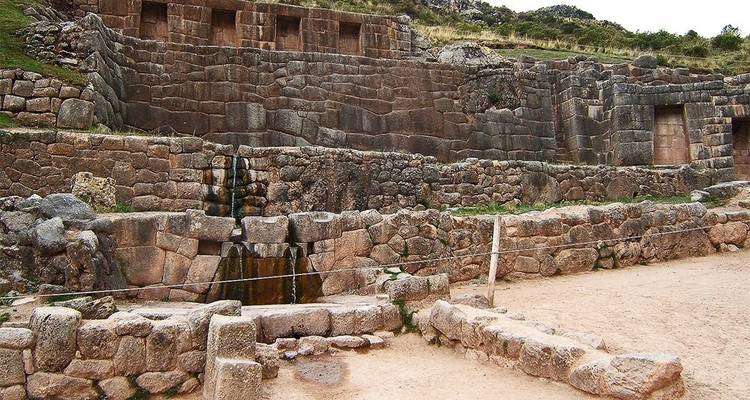 Terrasses de pierre et canaux d'eau sur un site archéologique.