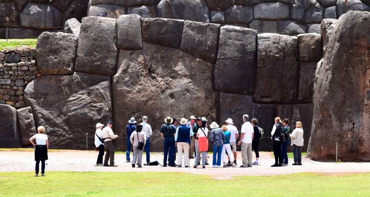 Groupe de touristes explorant de grandes ruines de pierre.