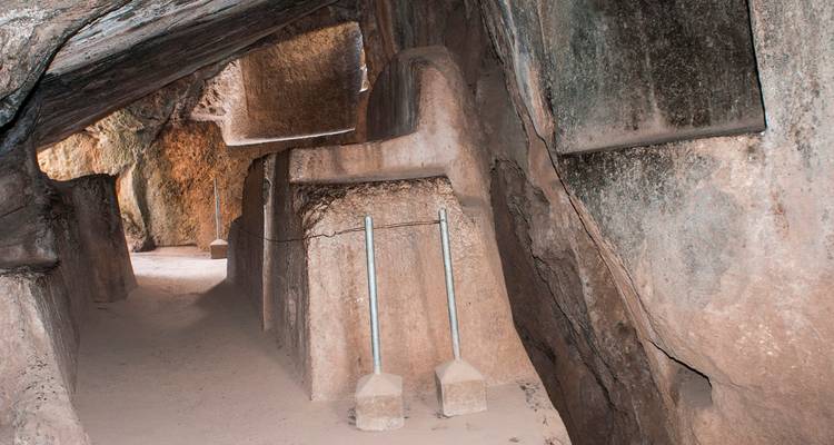 Passage étroit de grotte avec sculptures sur pierre.