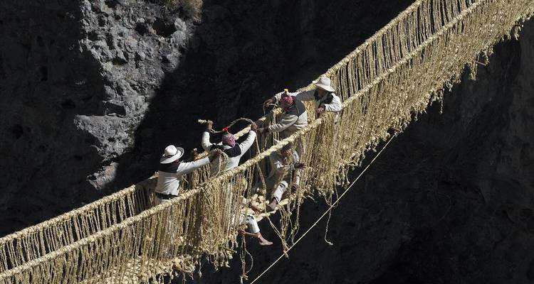 Mannen die een traditionele touwbrug repareren.