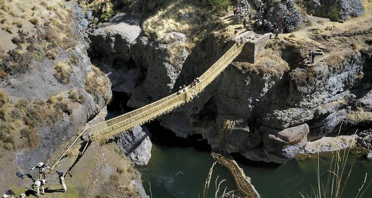 Luchtfoto van een touwbrug die een rivierkloof oversteekt.
