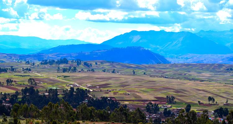 Expansive agricultural valley with mountains in the background.