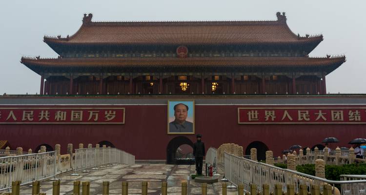 Retrato de Mao encima de la puerta principal de la Ciudad Prohibida en un día nublado con un guardia solitario