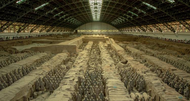 Enorme sala de excavación llena de filas de Guerreros de Terracota de tamaño natural extendiéndose hacia el horizonte