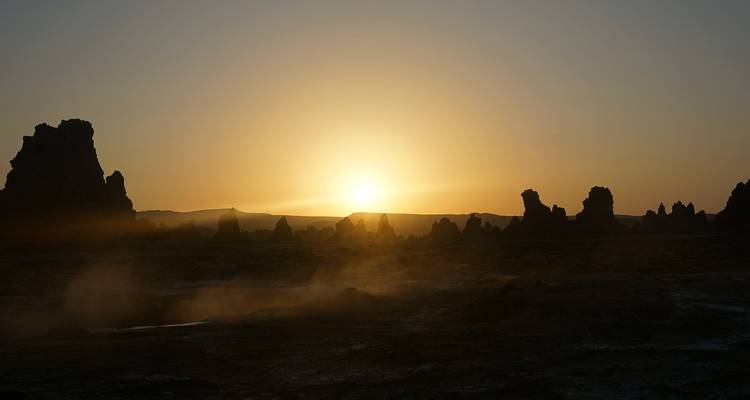Sunrise or sunset over jagged rock formations.