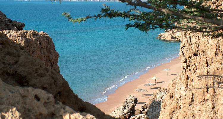 Secluded beach seen through rock formations.