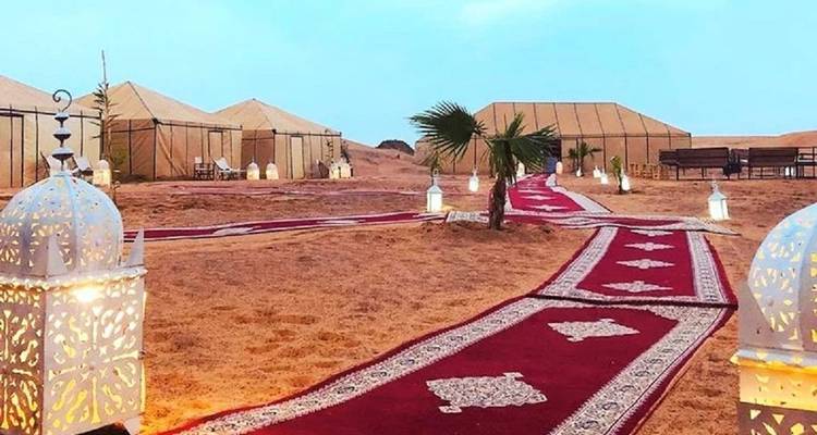 Desert camp setup with traditional elements and lighting.