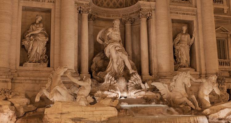 Trevi Fountain at night, beautifully illuminated.