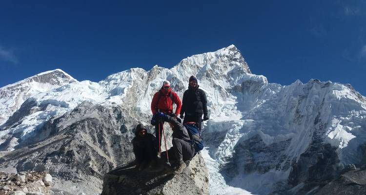 Gruppe von Bergsteigern mit Ausrüstung vor schneebedeckten Bergen.