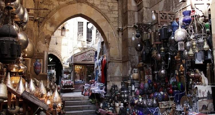 Drukke marktstraat met winkels en kleurrijke lampen.
