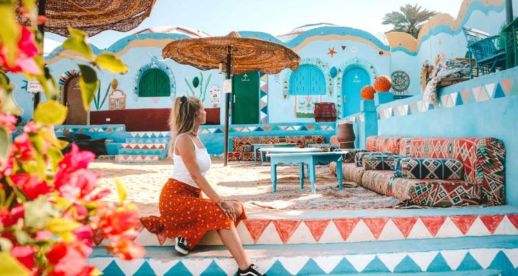 Kleurrijk Nubisch dorp met een persoon die poseert op de voorgrond.