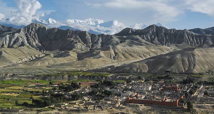 Une vue panoramique d'une ville entourée de montagnes spectaculaires.