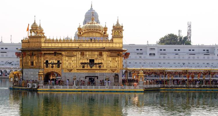 Gouden Tempel die zich weerkaatst in een waterpoel.