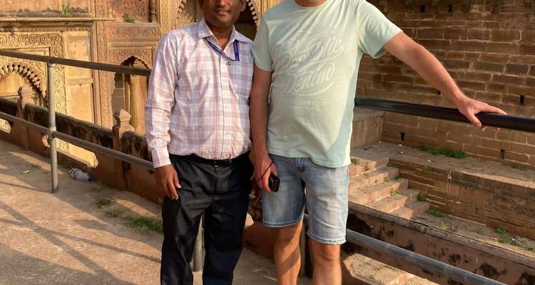 Twee mannen poseren bij oude structuren.