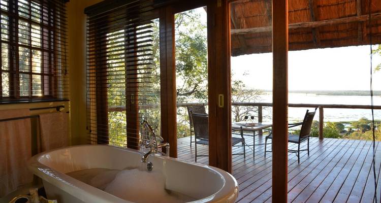 Luxurious bathtub with a view of the balcony and river.