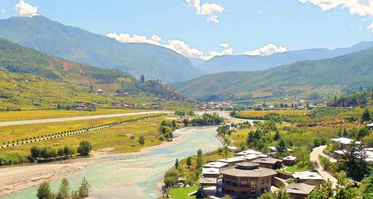 Vue pittoresque d'une rivière qui coule à travers une vallée avec une ville.