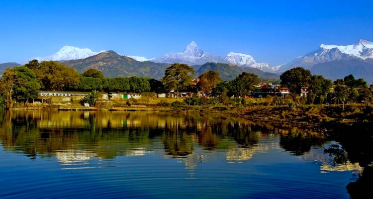 Malerische Aussicht auf schneebedeckte Berge, die sich in einem See in der Nähe von Pokhara spiegeln.