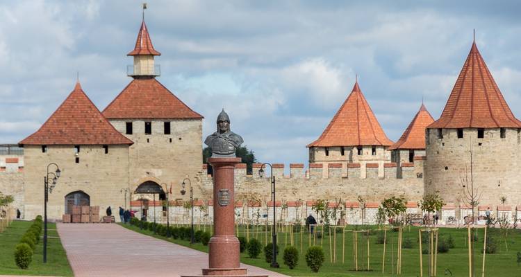 Historisch fort met roodgetooide torens en een standbeeld op de voorgrond.