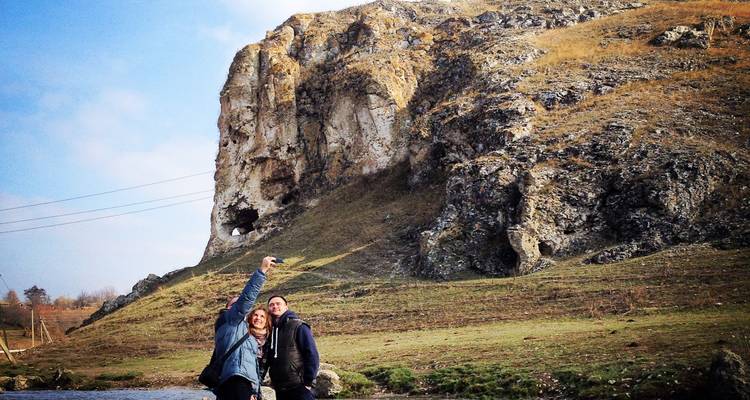 Couple prenant un selfie près d'une colline rocheuse.