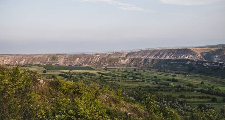 Vue panoramique d'une vallée verte avec des collines.