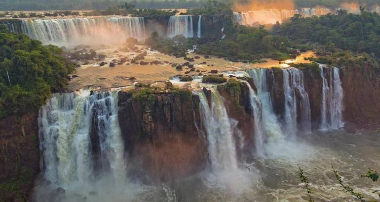 Cascadas majestuosas con neblina y vegetación exuberante.