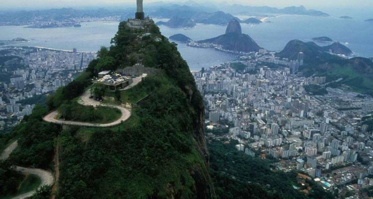 Vista aérea de una estatua famosa con vista a una ciudad y la costa.