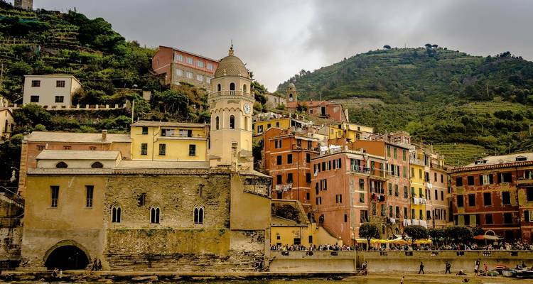 Colorful buildings with a clock tower near a waterfront.