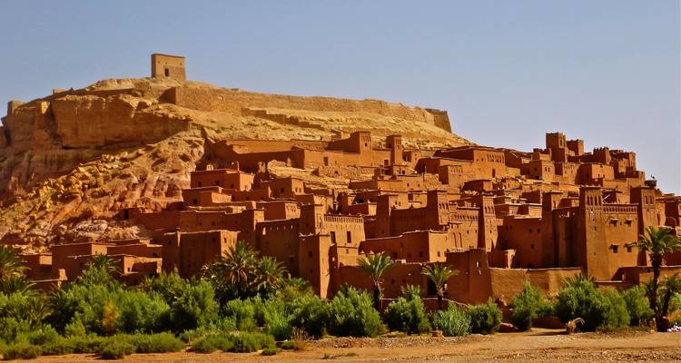 Historic Ait Ben Haddou in Morocco with earthen buildings and a hilltop structure.