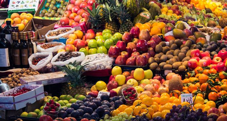 Colorful fruit market display with a variety of fruits and nuts.