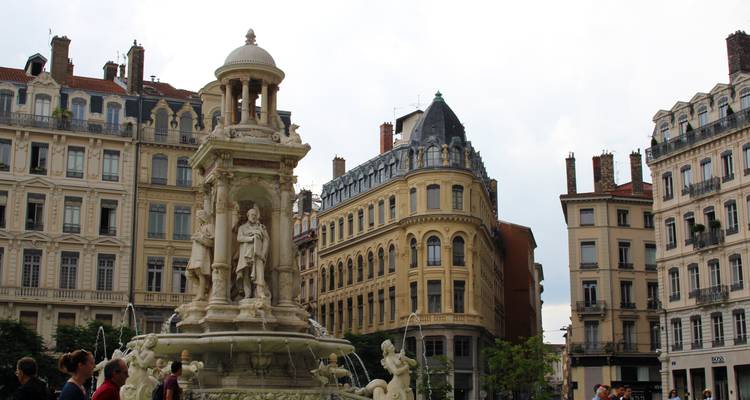 Statue und historische Gebäude auf einem französischen Stadtplatz.