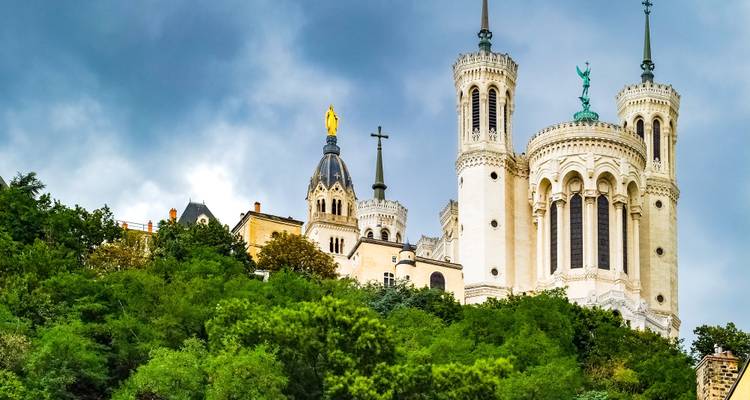 Notre-Dame de Fourvière Basilika auf einem Hügel vor bewölktem Himmel.