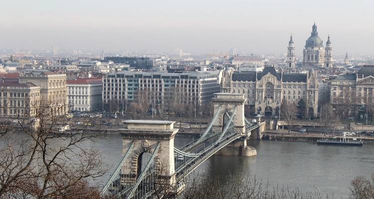 Paisaje urbano con un río y un puente histórico.