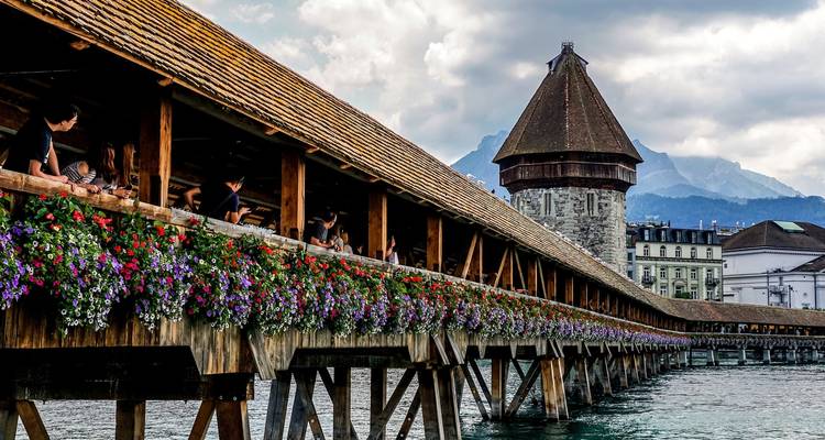 Kapellbrücke bridge in Lucerne adorned with colorful flowers.