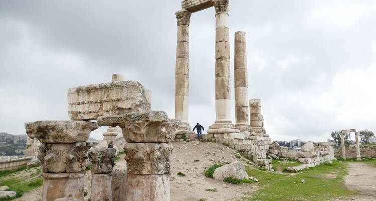 Ruins of ancient columns and a person walking.