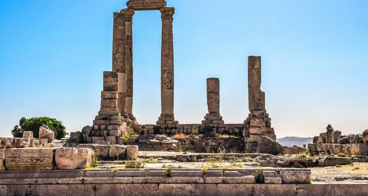 Ruins of ancient columns under a clear sky.