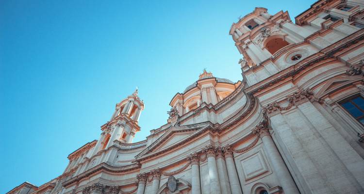 Looking up at ornate building facades with a deep blue sky.