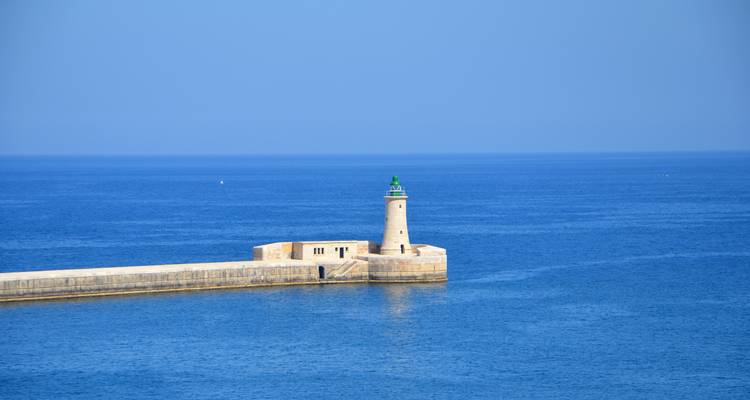 Lighthouse on a pier in the middle of the sea.